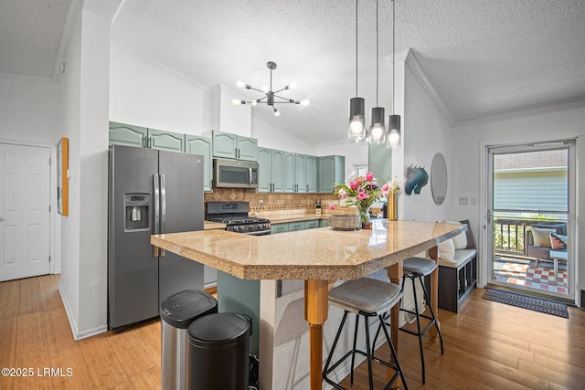 3 Stono Ct, Beaufort, SC 29902 - kitchen with appliances with stainless steel finishes, ornamental molding, lofted ceiling, a chandelier, and a kitchen breakfast bar
