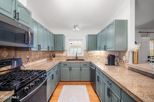 3 Stono Ct, Beaufort, SC 29902 - kitchen with appliances with stainless steel finishes, a sink, crown molding, light wood finished floors, and decorative backsplash