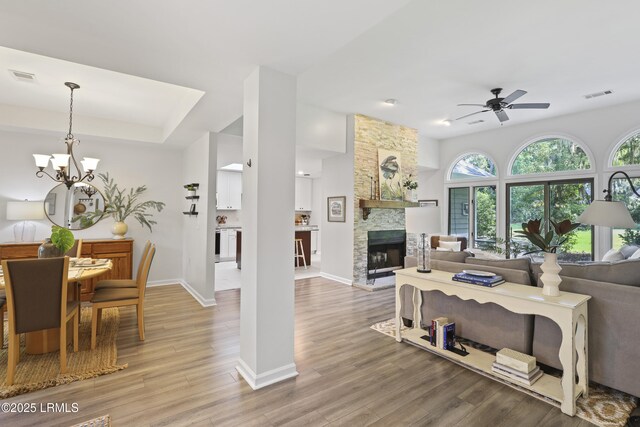 485 Bb Sams Dr, Saint Helena Island, SC 29920 - living room with a ceiling fan, wood finished floors, a fireplace, a chandelier, and a tray ceiling