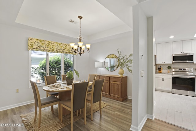 485 Bb Sams Dr, Saint Helena Island, SC 29920 - dining space featuring a chandelier, a tray ceiling, light wood-style flooring, and recessed lighting