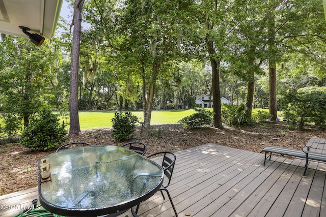 485 Bb Sams Dr, Saint Helena Island, SC 29920 - wooden deck with outdoor dining area, view of scattered trees, and a yard