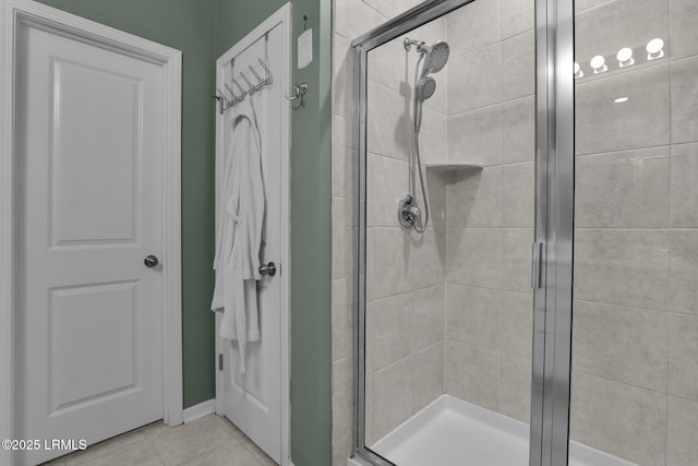 bathroom with a shower with door and tile patterned floors