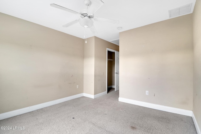 carpeted spare room featuring ceiling fan