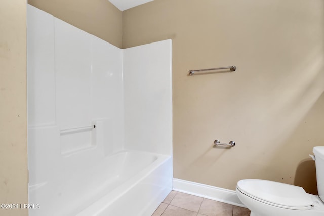 bathroom featuring tile patterned flooring, a washtub, and toilet