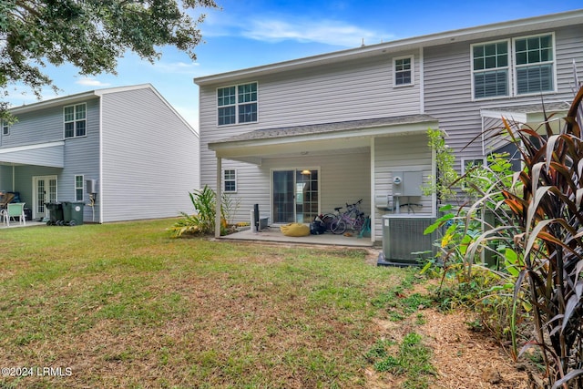 rear view of property featuring a patio, a yard, and central AC unit