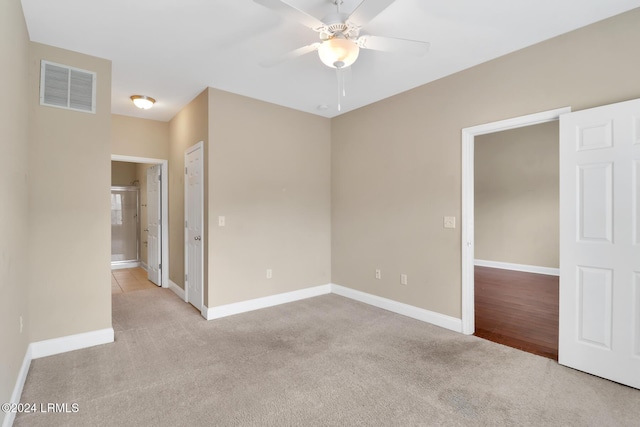 carpeted spare room featuring ceiling fan