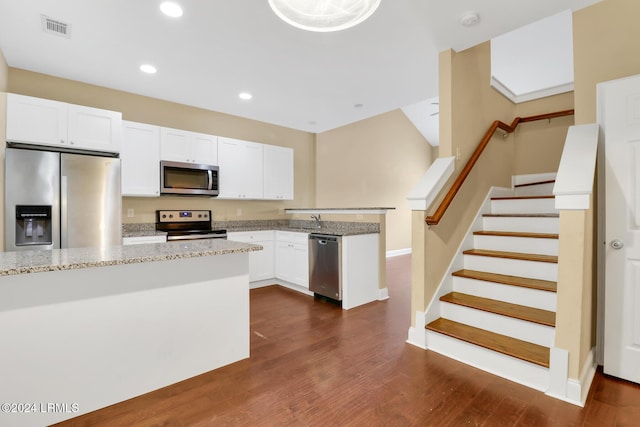 kitchen with stainless steel appliances, white cabinetry, dark hardwood / wood-style floors, and light stone counters