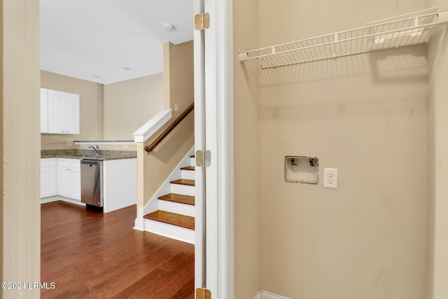 stairs featuring wood-type flooring and sink