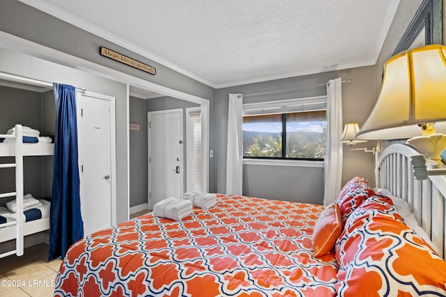 tiled bedroom with crown molding, a closet, and a textured ceiling