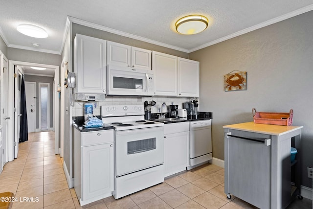 kitchen with sink, white appliances, light tile patterned floors, a textured ceiling, and white cabinets