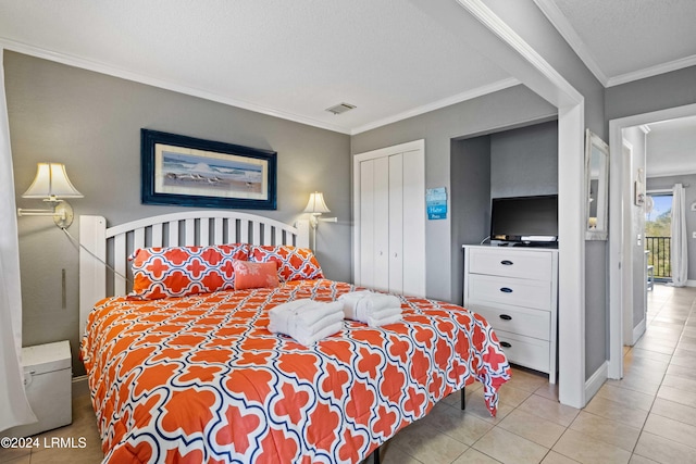 tiled bedroom with crown molding, a textured ceiling, and a closet