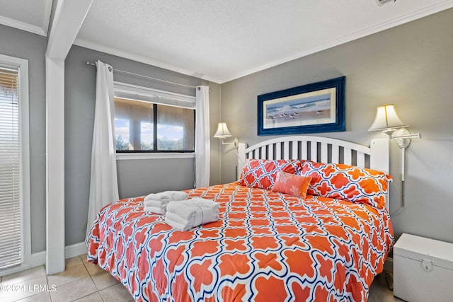 bedroom featuring tile patterned floors, ornamental molding, multiple windows, and a textured ceiling