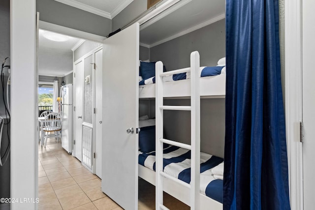 bedroom featuring white refrigerator, light tile patterned flooring, and ornamental molding