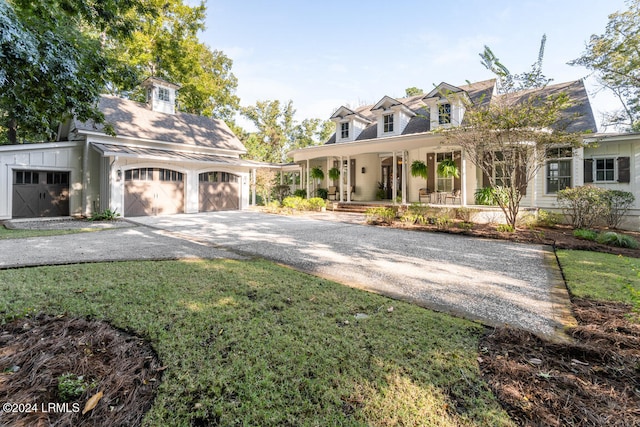 cape cod house with a porch, a garage, and a front yard