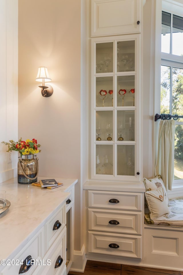 interior space with white cabinetry and light stone counters