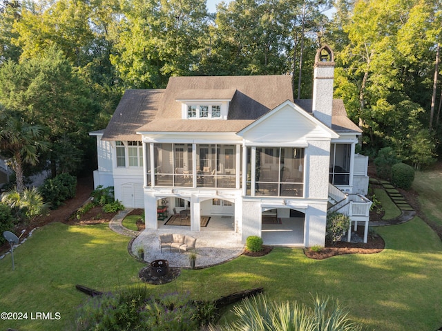 back of house featuring a patio area, a sunroom, and a lawn