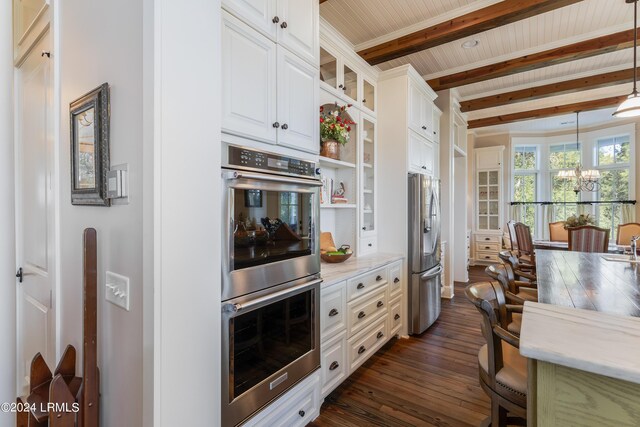 kitchen featuring beamed ceiling, white cabinetry, appliances with stainless steel finishes, pendant lighting, and light stone countertops