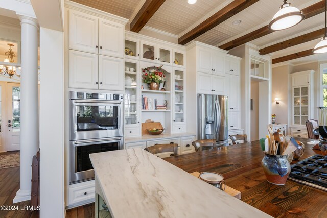 kitchen featuring pendant lighting, stainless steel appliances, beam ceiling, and white cabinets