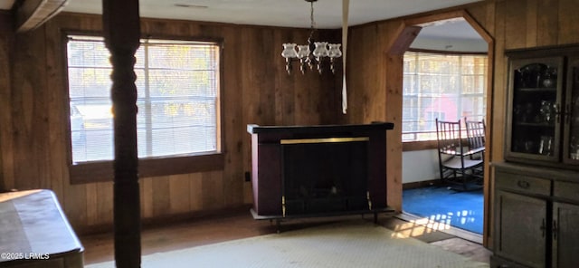 living room featuring a chandelier and wooden walls