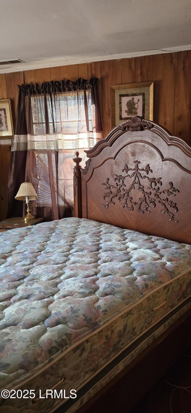 bedroom with crown molding and wooden walls