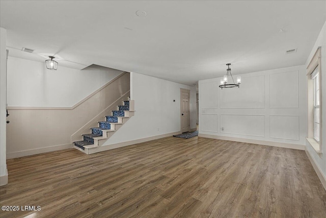 20 Pennyroyal Way, Beaufort, SC 29906 - unfurnished living room with wood finished floors, a chandelier, stairs, and a decorative wall