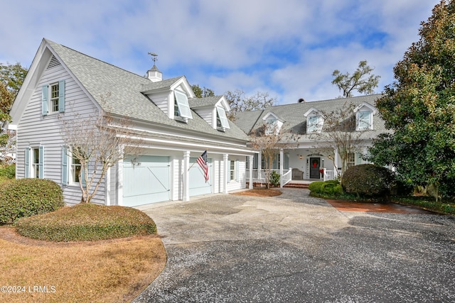 cape cod-style house with a porch and a garage