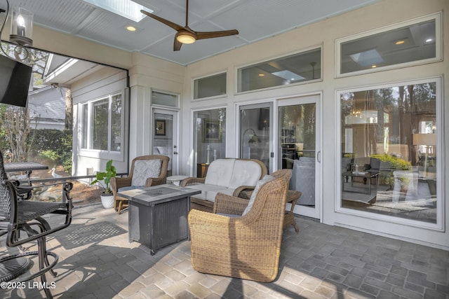 sunroom / solarium with ceiling fan and a skylight