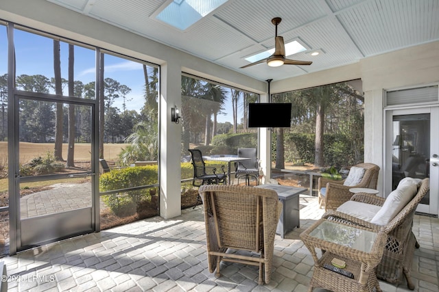 sunroom / solarium featuring a skylight and ceiling fan