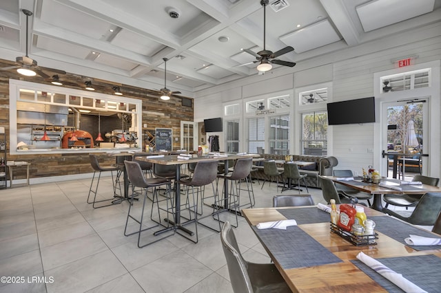 tiled dining space with coffered ceiling, beam ceiling, and wood walls