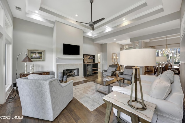 living room featuring crown molding, a tray ceiling, dark hardwood / wood-style flooring, and a high ceiling