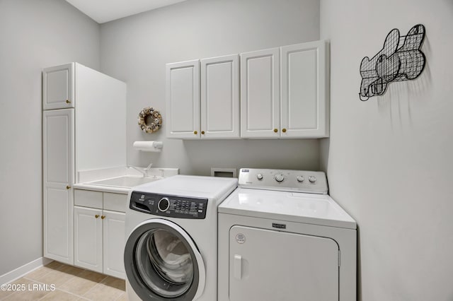 laundry area featuring cabinets, washer and clothes dryer, and sink