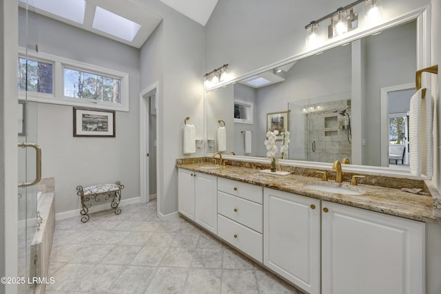 bathroom with plus walk in shower, a wealth of natural light, vanity, and a skylight