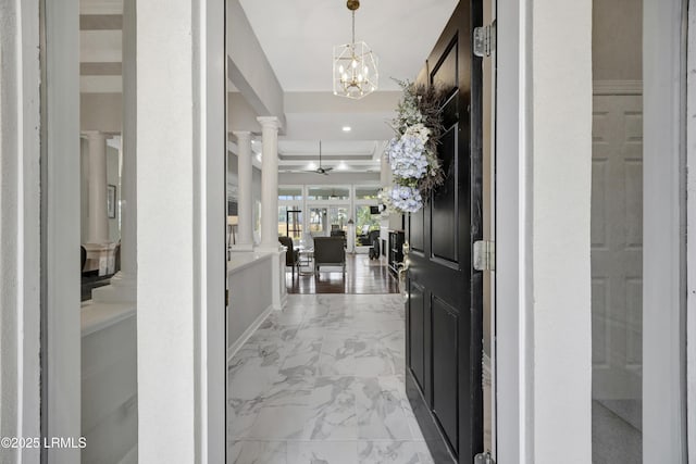 foyer entrance featuring ceiling fan with notable chandelier and decorative columns