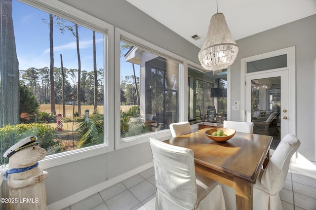 sunroom / solarium with plenty of natural light and a chandelier