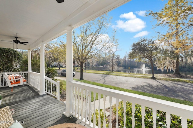 wooden terrace with covered porch and a ceiling fan