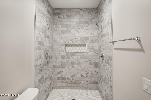 bathroom with tiled shower and toilet