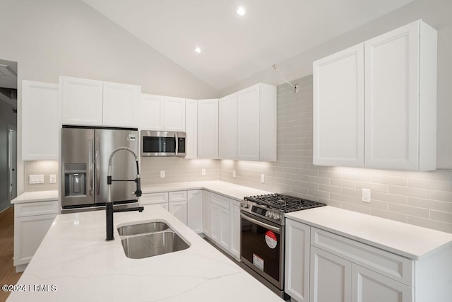 kitchen with appliances with stainless steel finishes, sink, and white cabinets