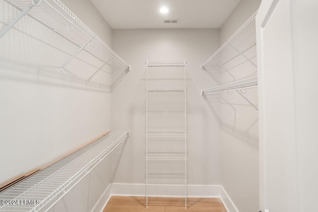 spacious closet with hardwood / wood-style flooring