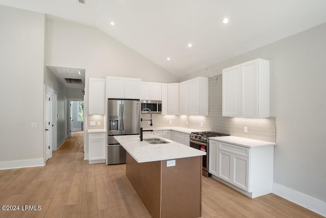 kitchen featuring white cabinetry, stainless steel appliances, and a center island with sink