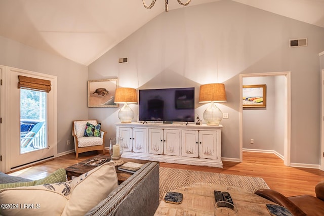 living room featuring high vaulted ceiling and light hardwood / wood-style floors