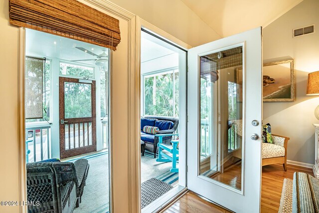 doorway to outside with wood-type flooring and lofted ceiling