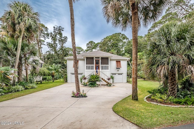 view of front of house with a garage, a front lawn, and a porch