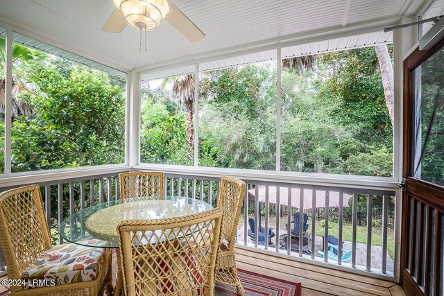 sunroom / solarium featuring ceiling fan and a healthy amount of sunlight