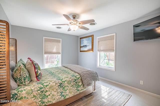 bedroom with multiple windows, ceiling fan, and carpet flooring