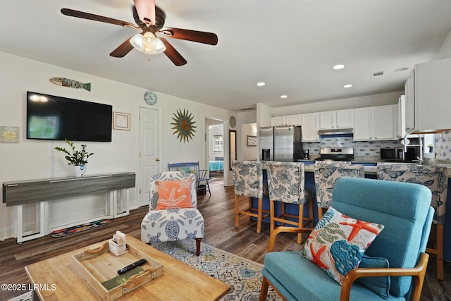 living area featuring dark wood-style floors, a ceiling fan, and recessed lighting