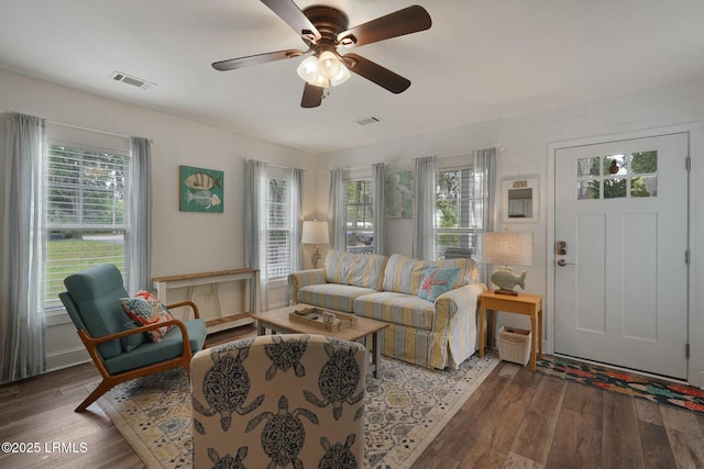 living area featuring visible vents, a healthy amount of sunlight, and wood-type flooring