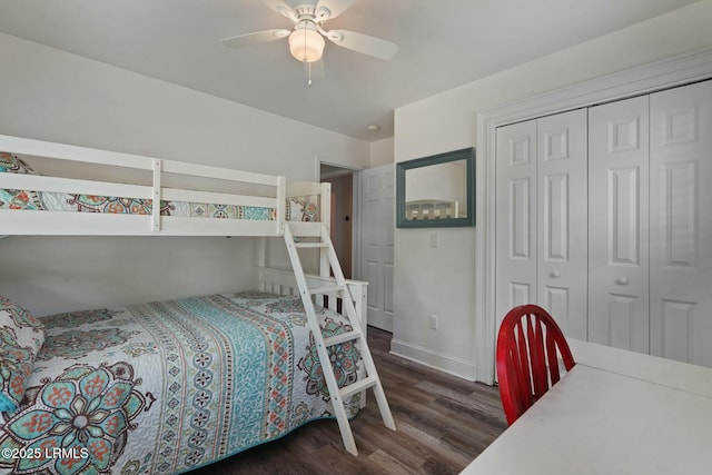 bedroom with dark wood-style floors, baseboards, a ceiling fan, and a closet
