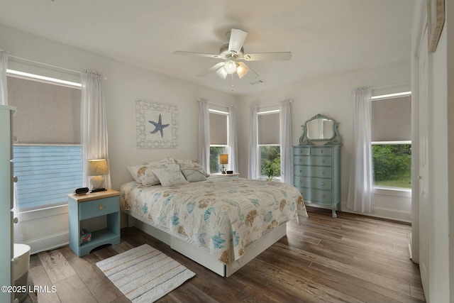 bedroom featuring baseboards, a ceiling fan, and dark wood-type flooring