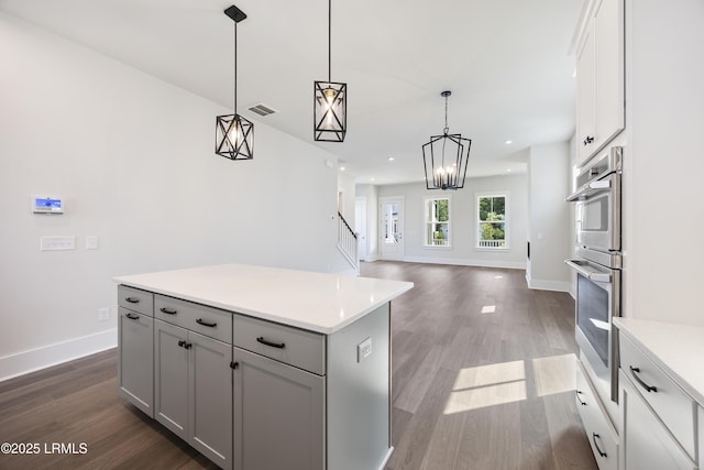 14 Skipperling Ct, Bluffton, SC 29909 - kitchen with dark wood finished floors, light countertops, baseboards, gray cabinets, and pendant lighting