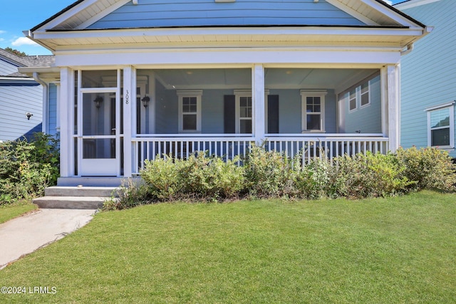 view of front of home with a front yard and a sunroom